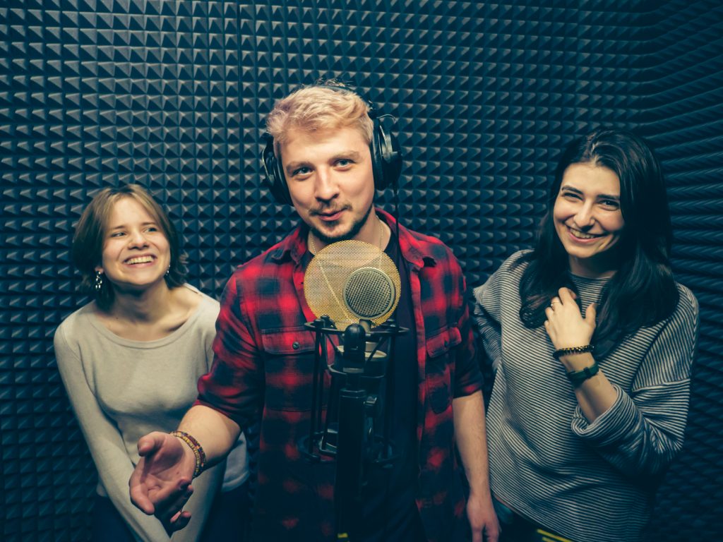 Мужчина и 2 девушки на записи песни в студии